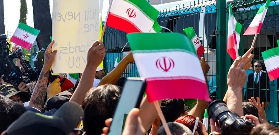 Crowd holding Iranian flags at protest event