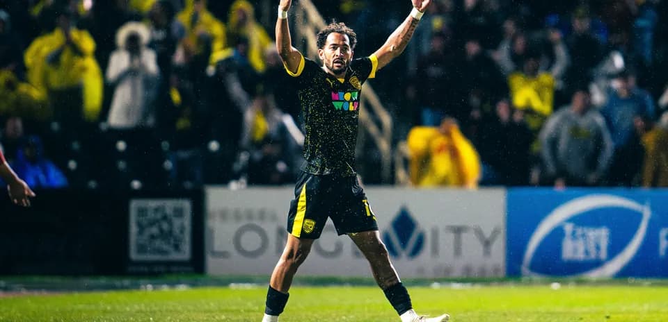 New Mexico United player celebrating in the rain