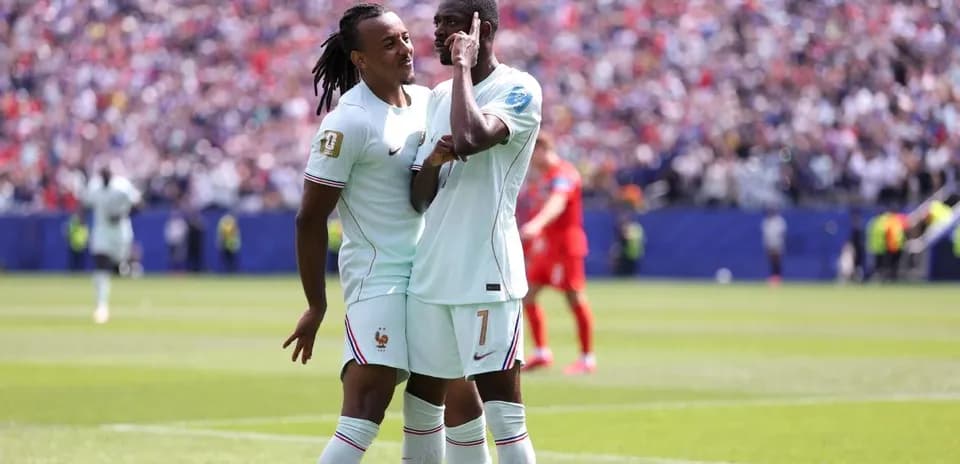Two French players celebrating a goal on the field