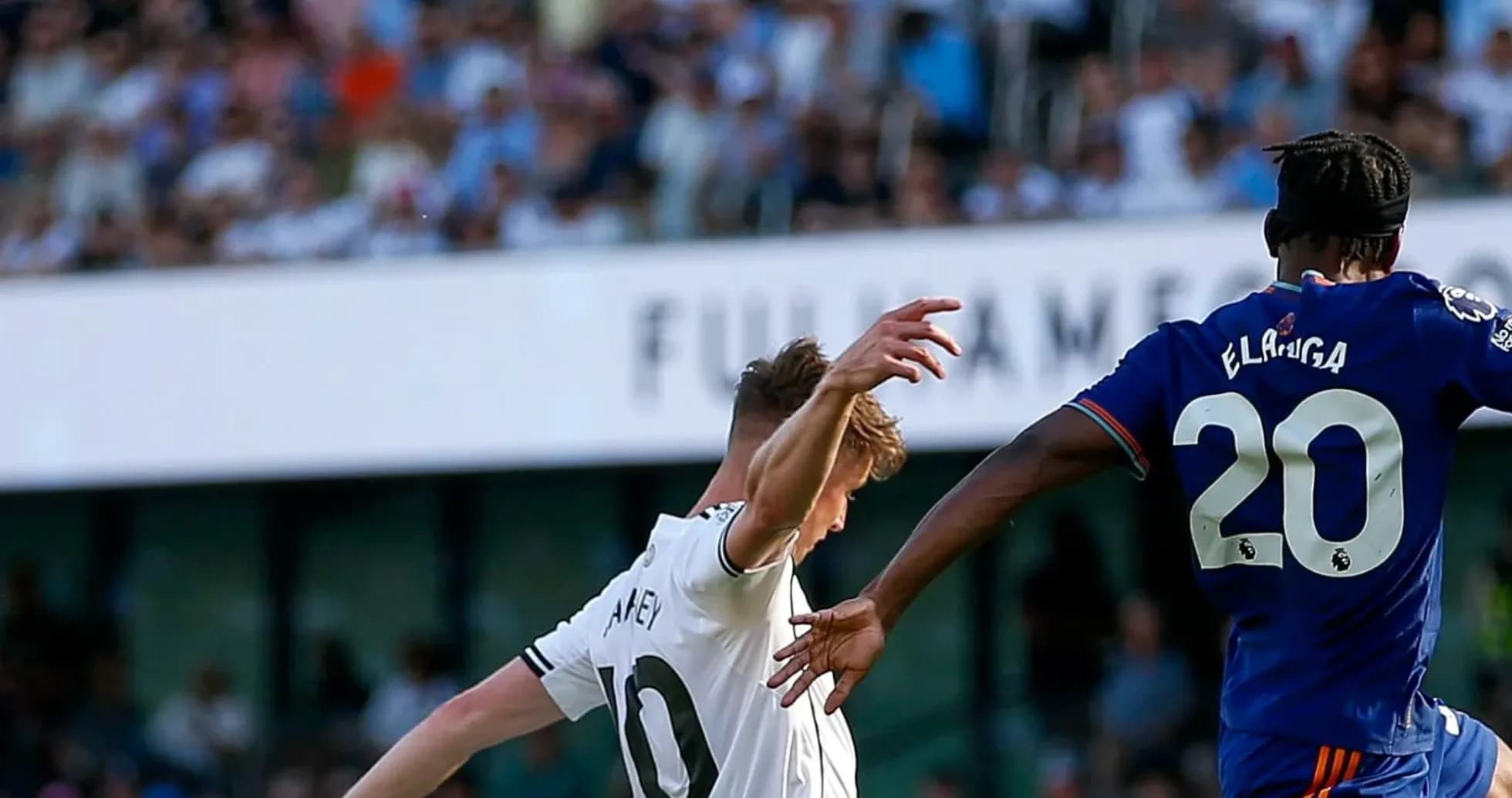 Fulham player challenging Newcastle opponent during match