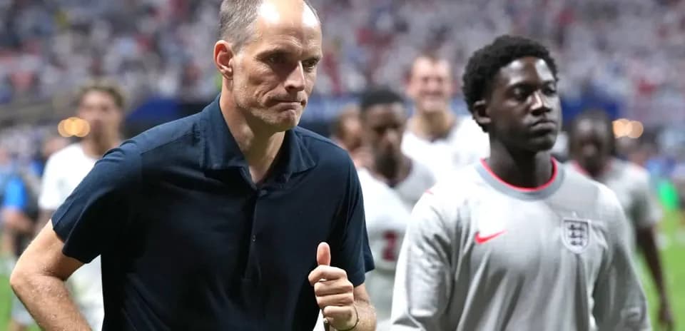 Coach and players walking off the pitch after match