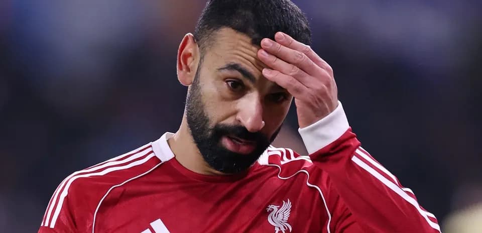 Player in red jersey with hand on forehead