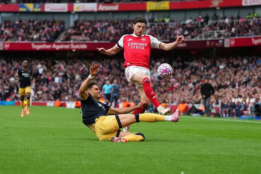 Arsenal player evading a tackle during match