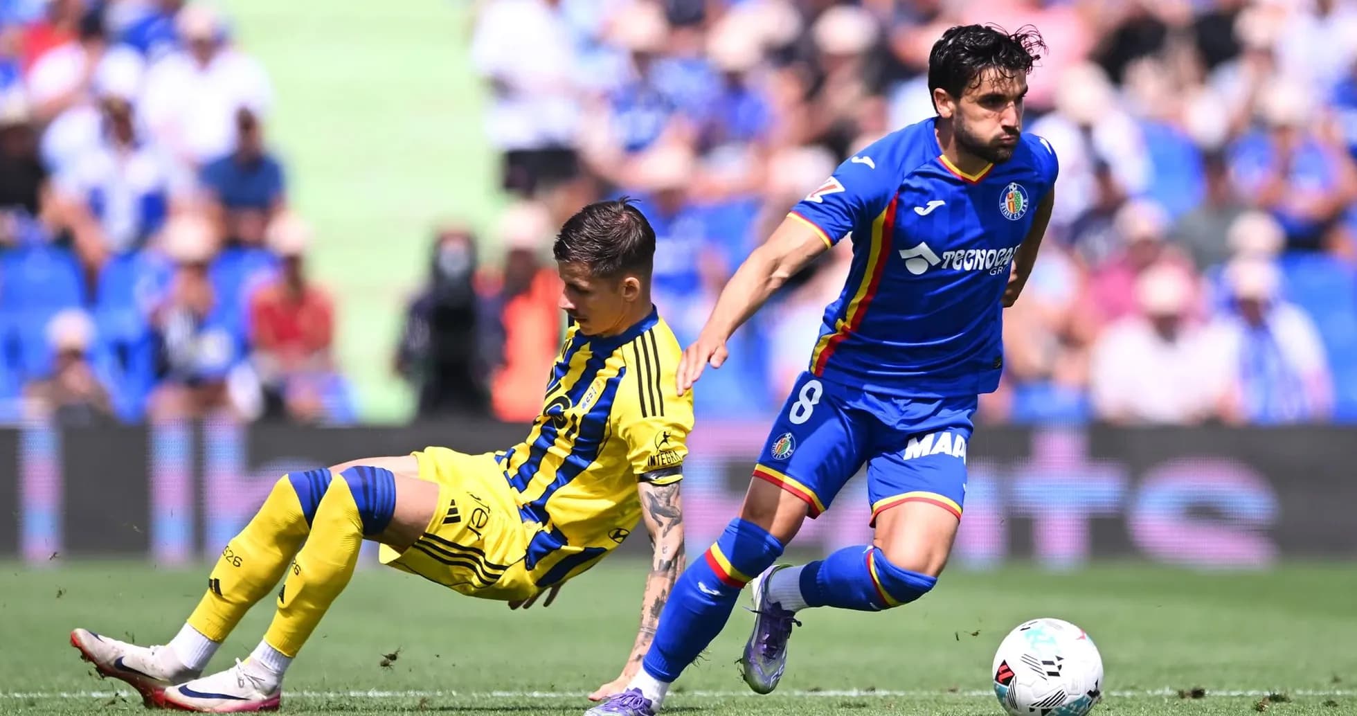 Oviedo player challenged by Getafe opponent
