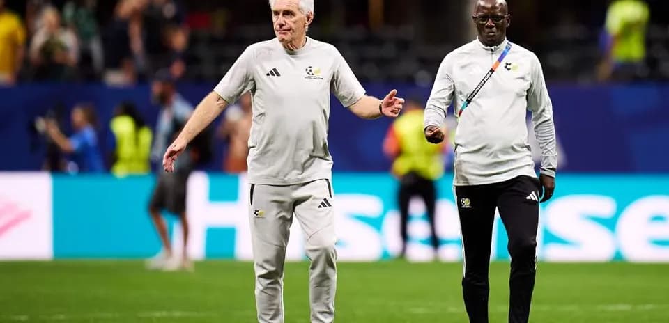 Coaches walking on the pitch before the match
