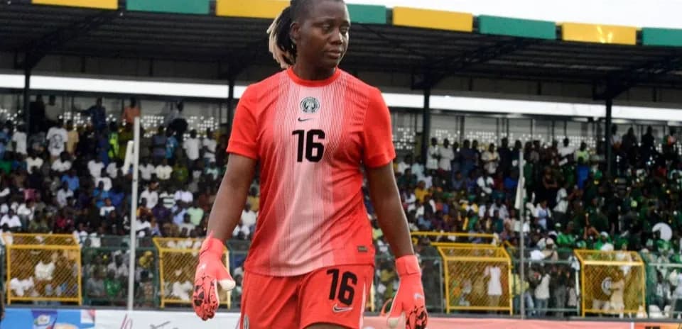 Goalkeeper wearing red kit walking on the pitch