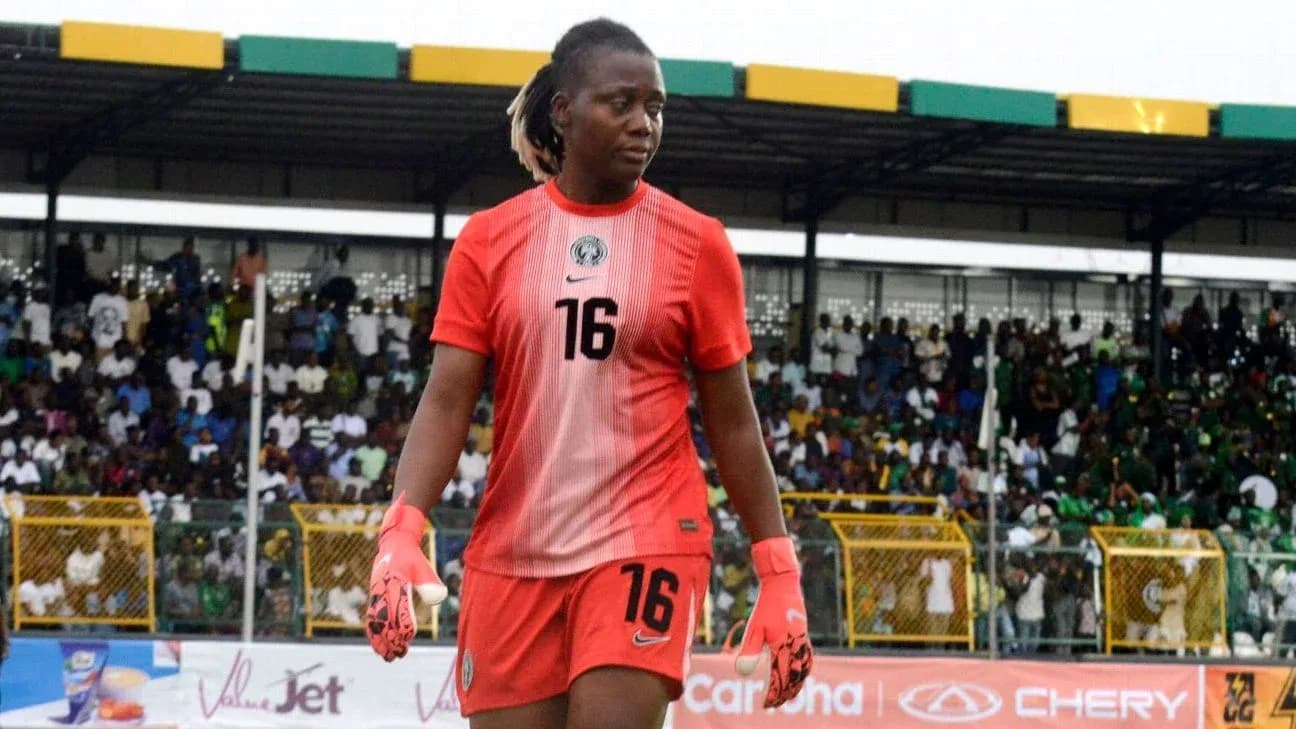 Goalkeeper wearing red kit walking on the pitch