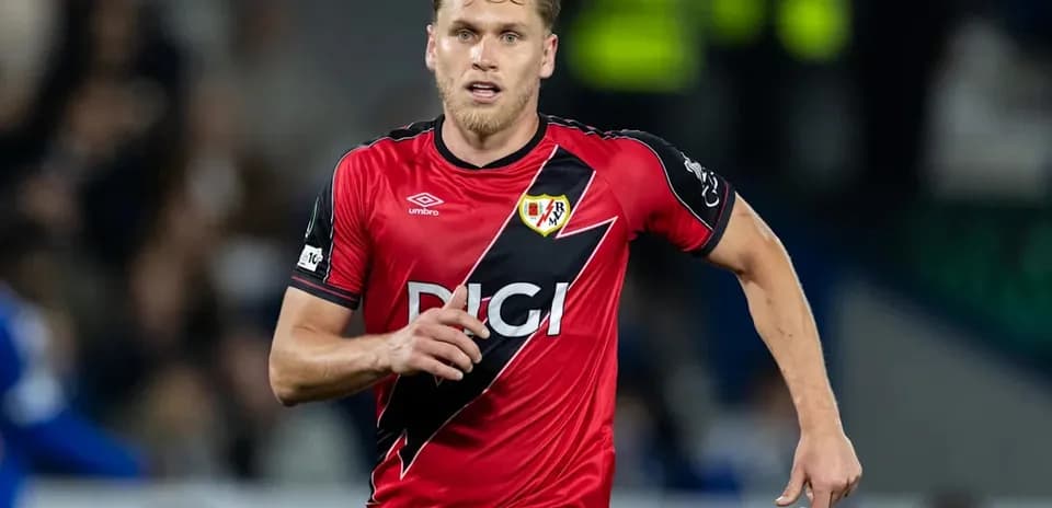 Player running in red Rayo Vallecano kit