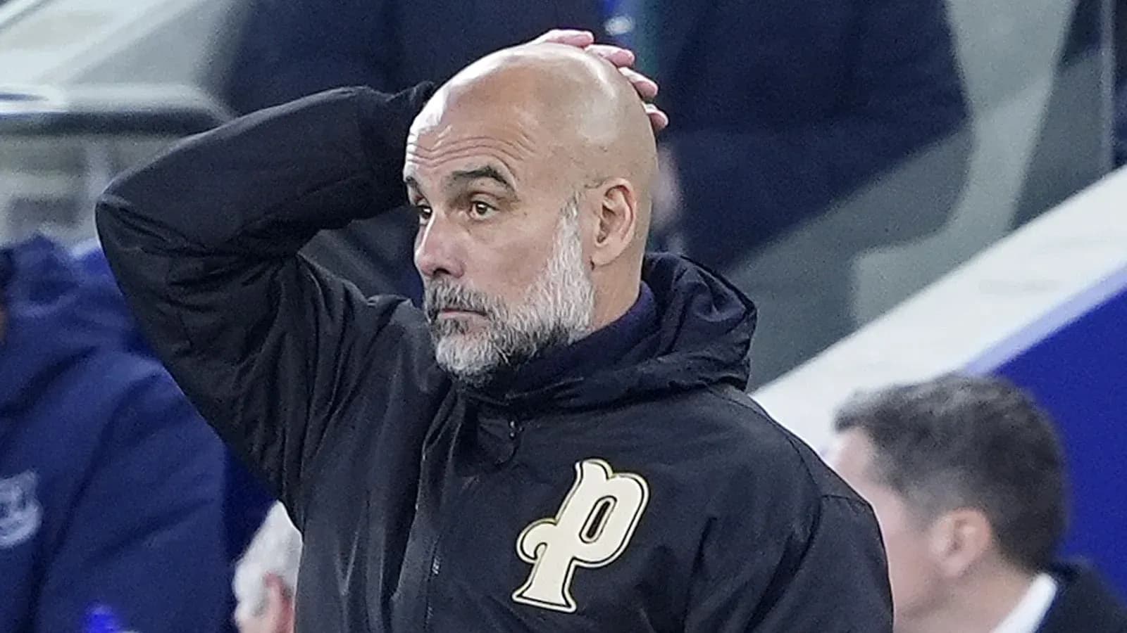 Coach with bald head looking concerned on sidelines