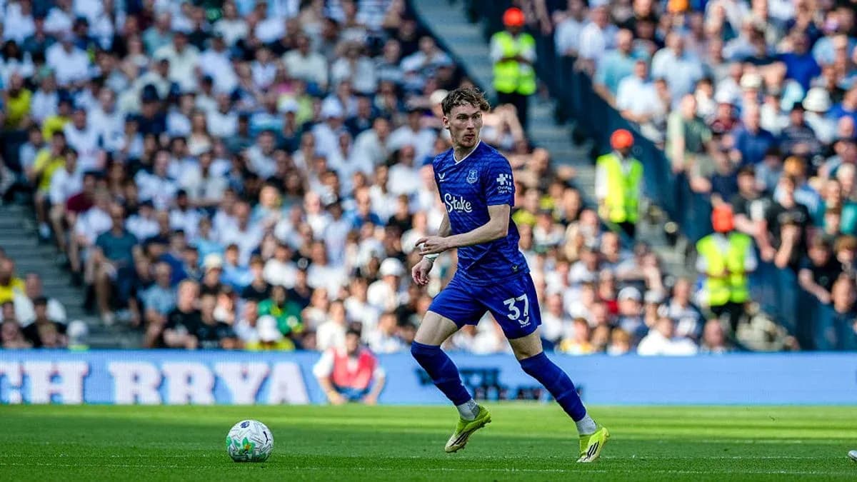 Player in blue kit running with the ball on pitch