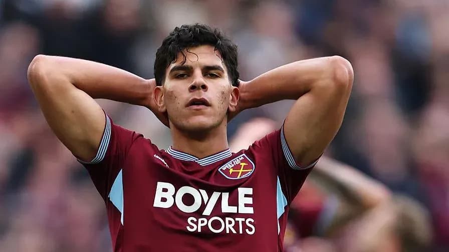 Player in maroon jersey with hands on head