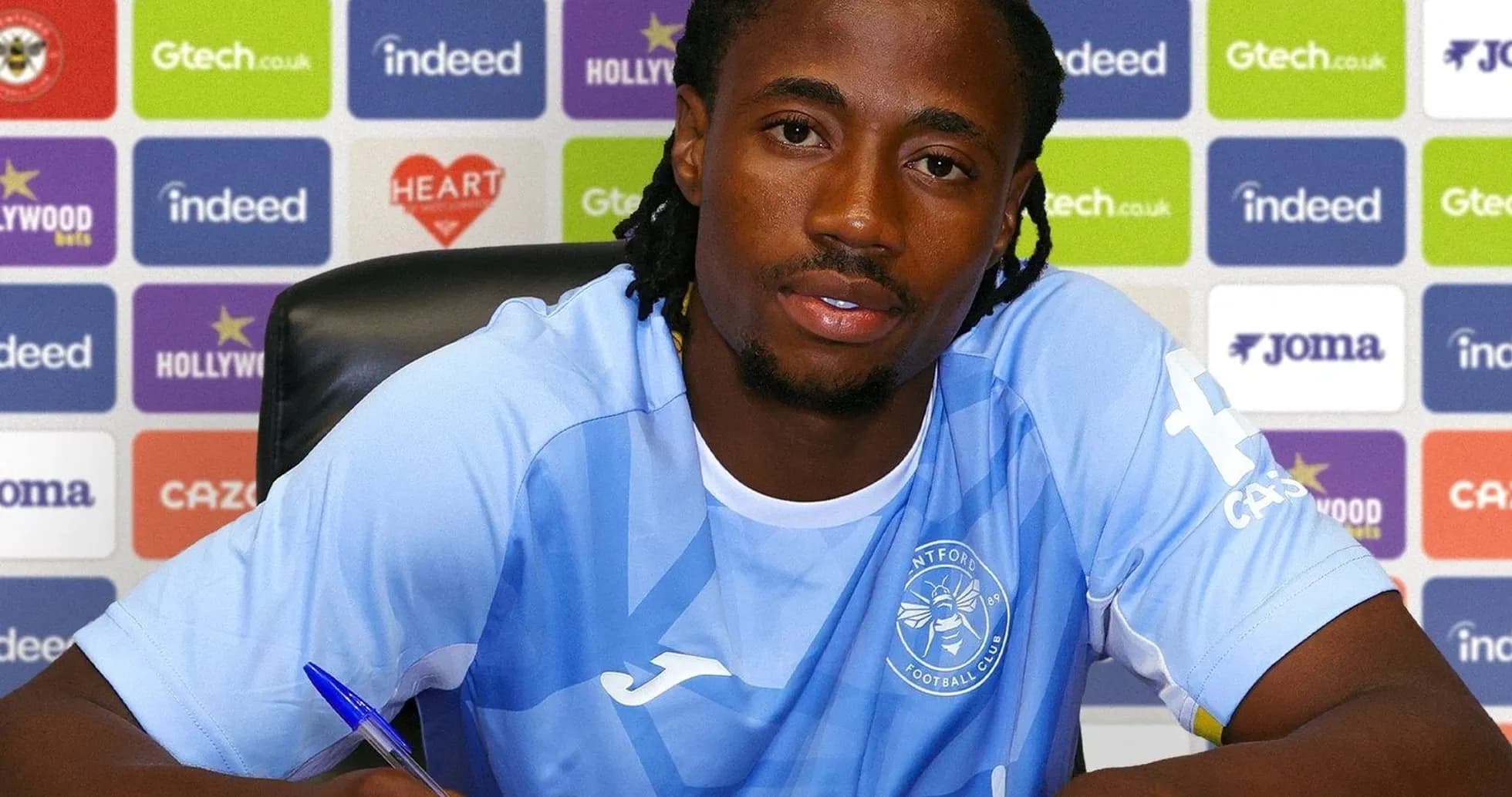 Player signing contract at press conference table