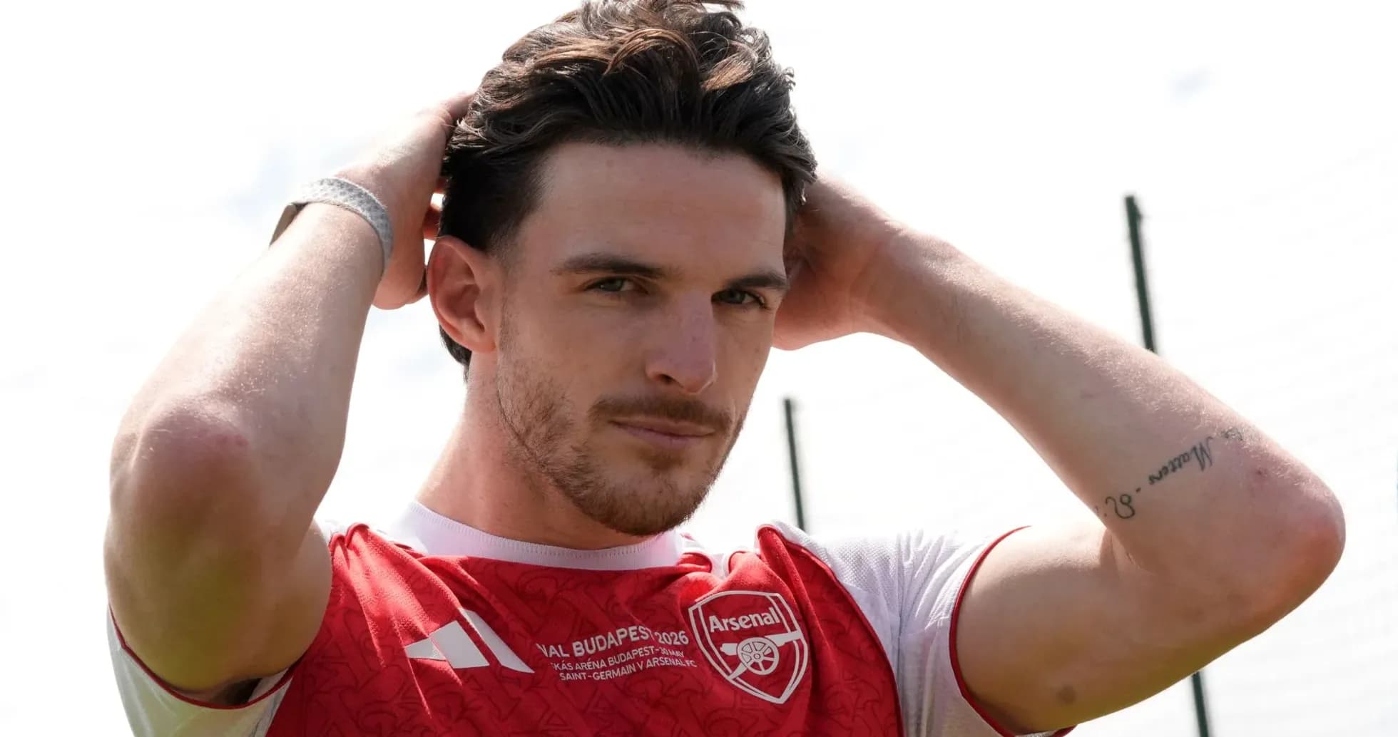 Player adjusting hair while wearing Arsenal jersey