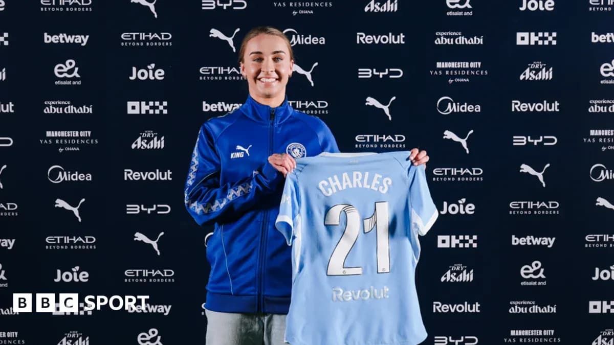Player holding Manchester City jersey during signing event