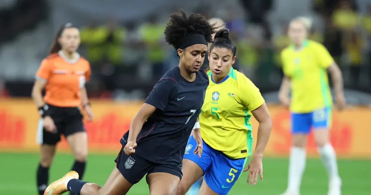 US player dribbling past Brazilian defender during match