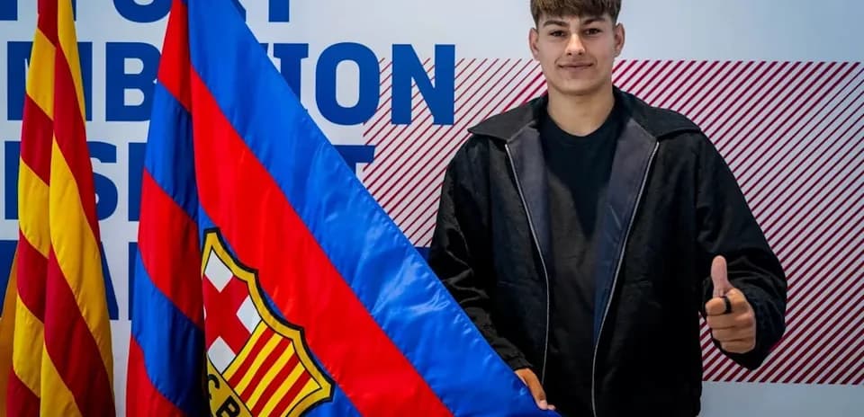 Player posing with FC Barcelona flag during announcement