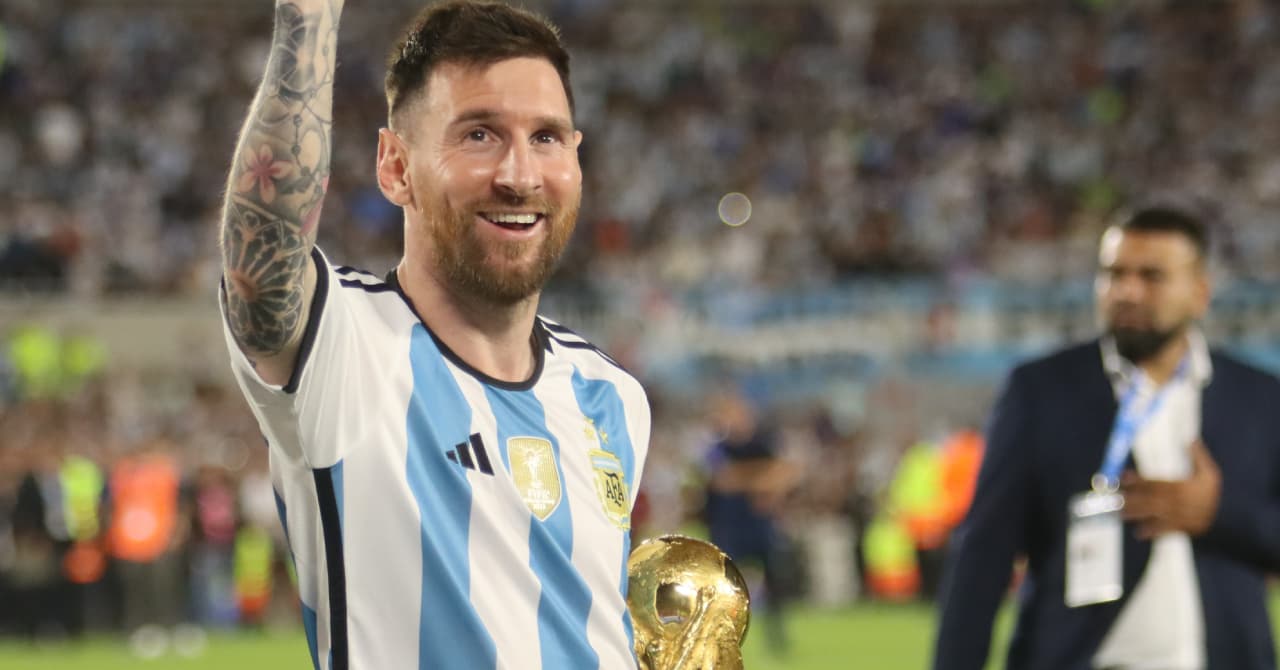 Player celebrating with World Cup trophy on field