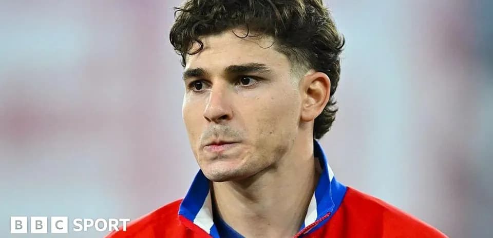 Player wearing red jersey during match preparation