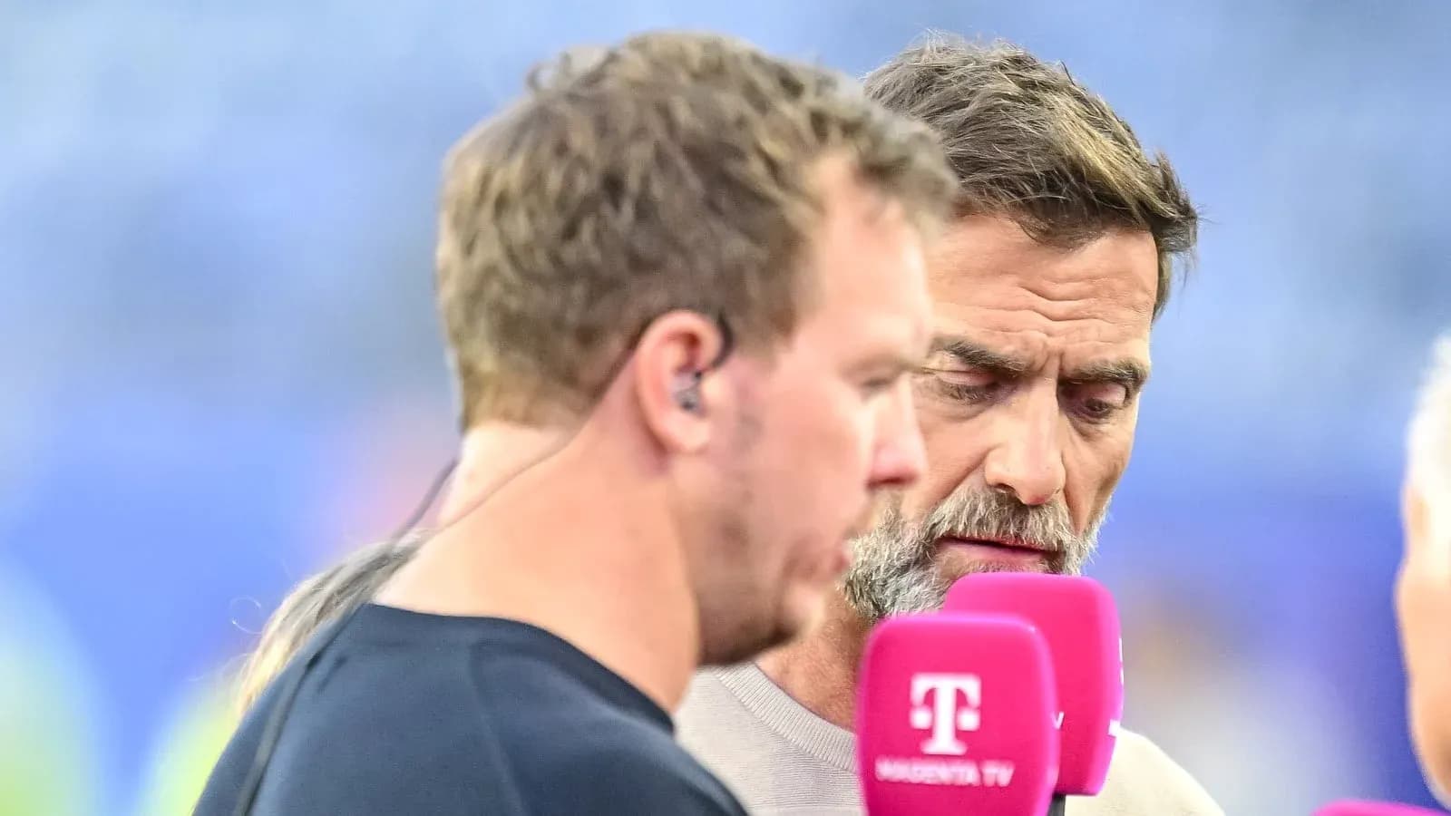 Two men discussing during a sports broadcast interview