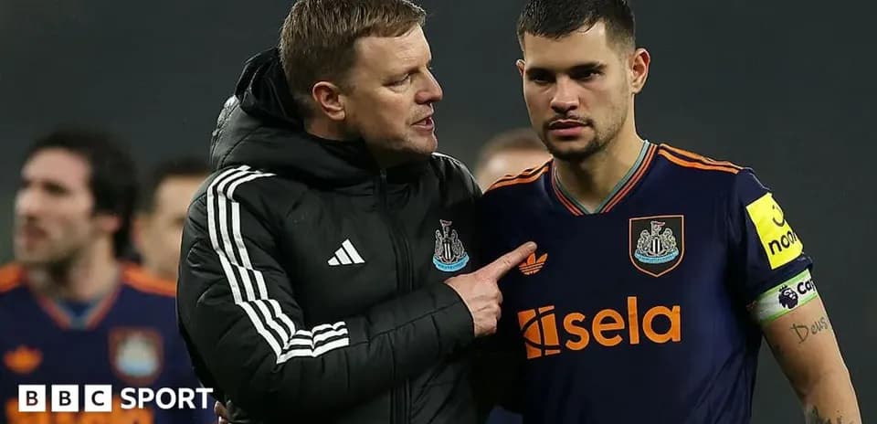 Manager discussing strategy with player on pitch