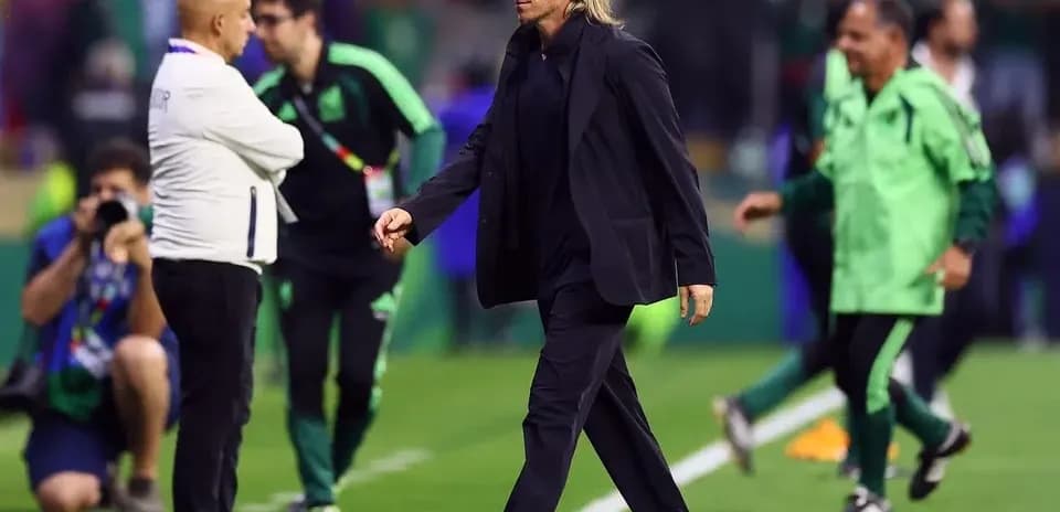 Coach walking on the pitch during match