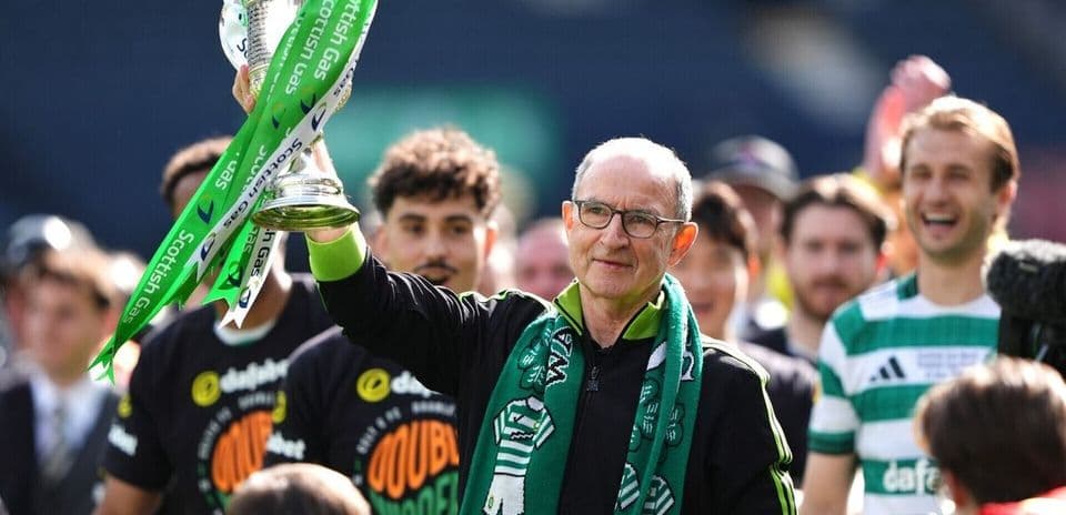 Manager holding trophy with celebrating team members