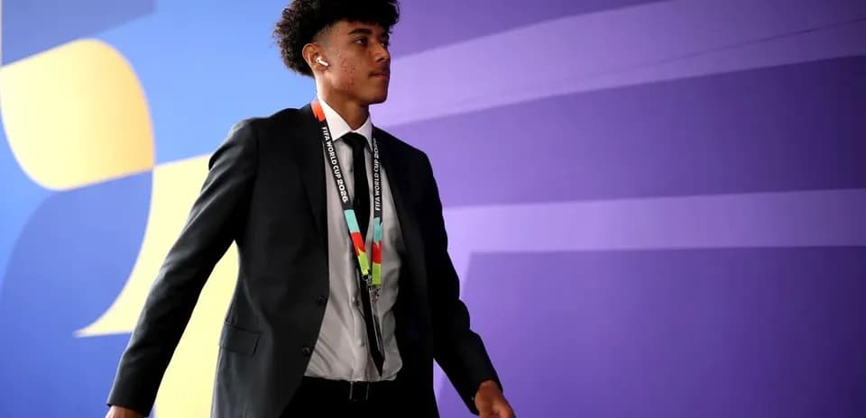 Player walking in formal attire with accreditation lanyard