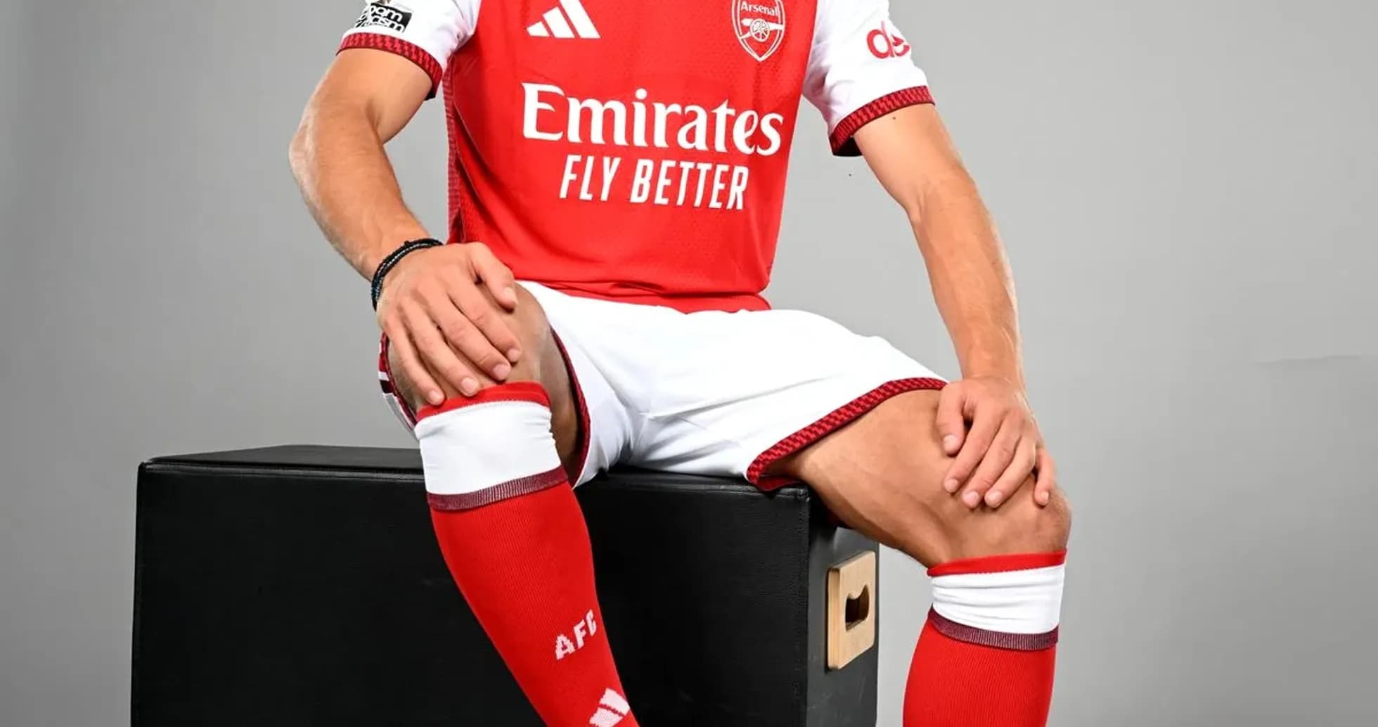 Player in Arsenal kit sitting on a box