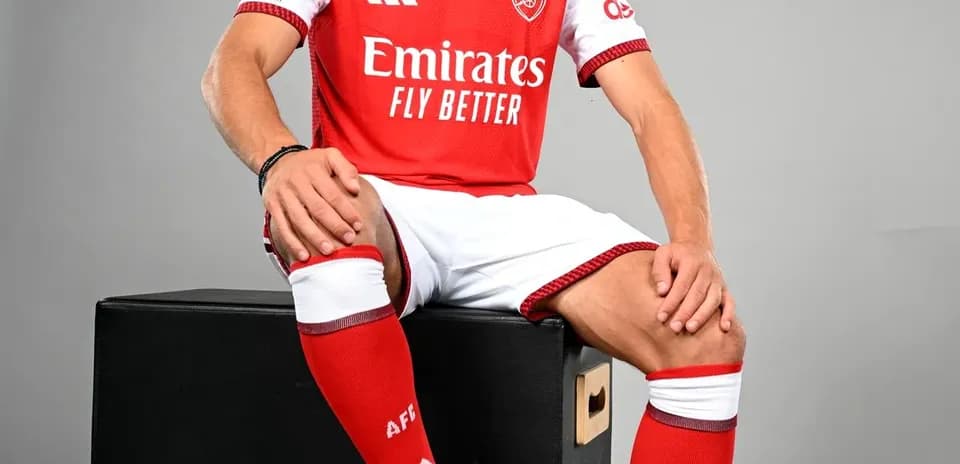 Player in Arsenal kit sitting on a box