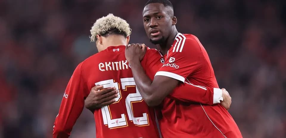 Two players in red jerseys embracing during match