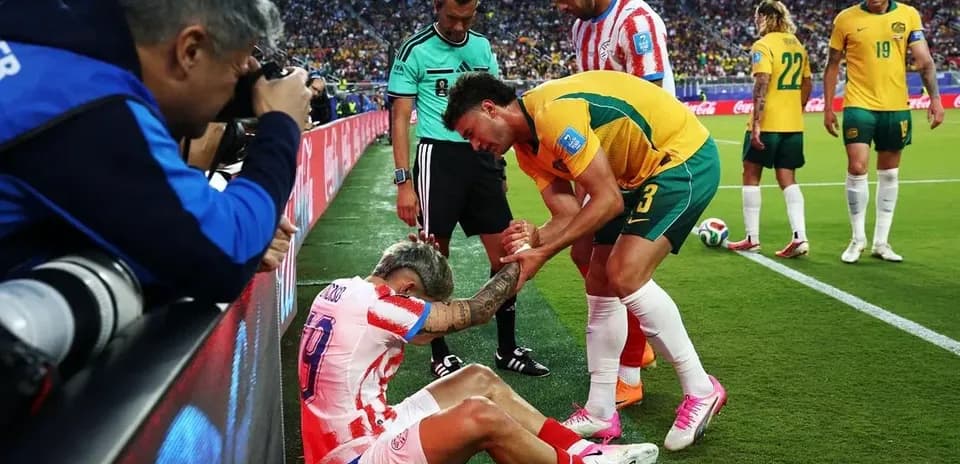 Player receiving assistance from teammates on sideline