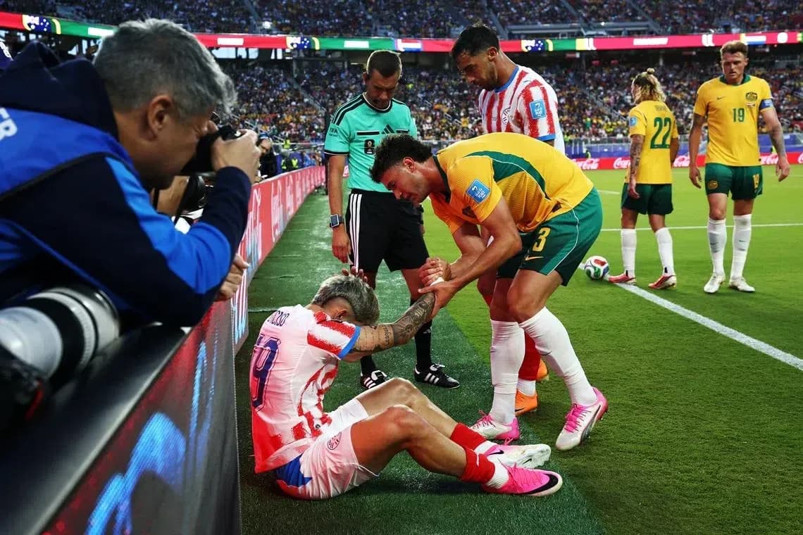 Player receiving assistance from teammates on sideline