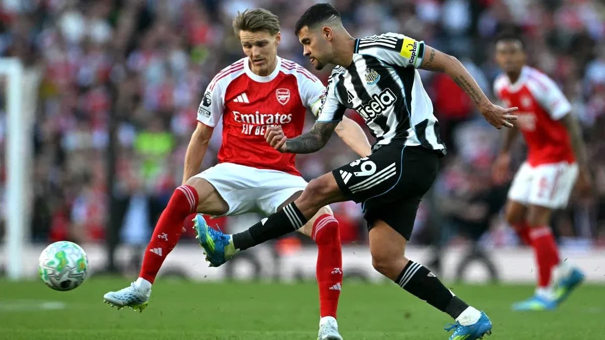 Newcastle player kicking the ball against Arsenal opponent