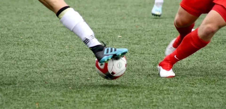 Two players competing for the ball in football