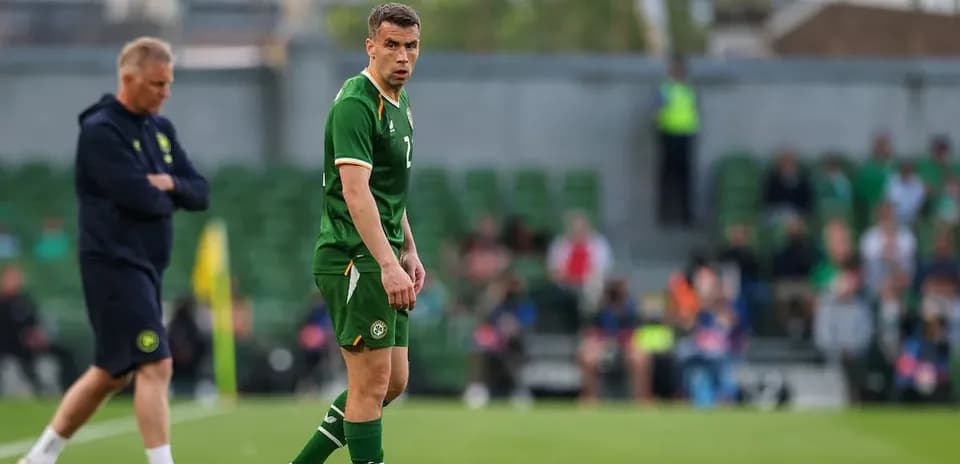 Player in green kit during training session on pitch