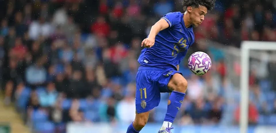 Player in blue kit controlling a soccer ball