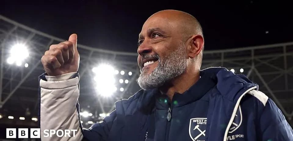 Coach celebrating with a thumbs up at stadium