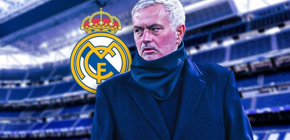 Manager in front of Real Madrid logo at stadium