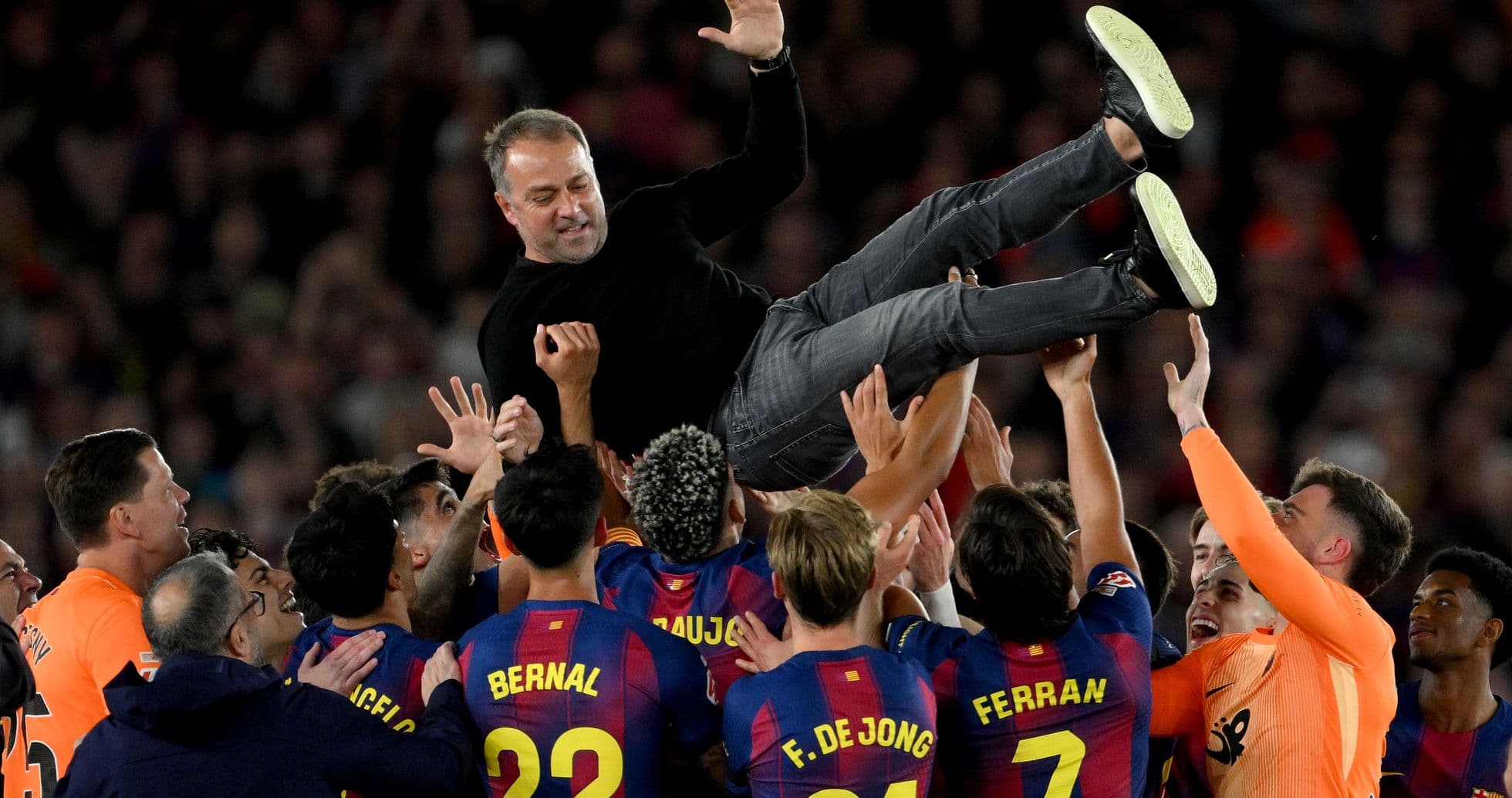 Barcelona players celebrating by lifting their coach
