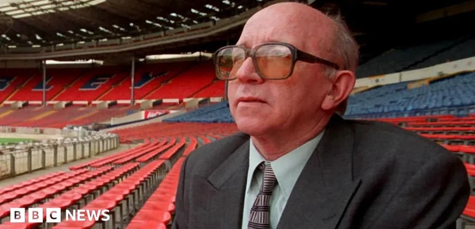Man sitting in empty stadium seats, looking ahead