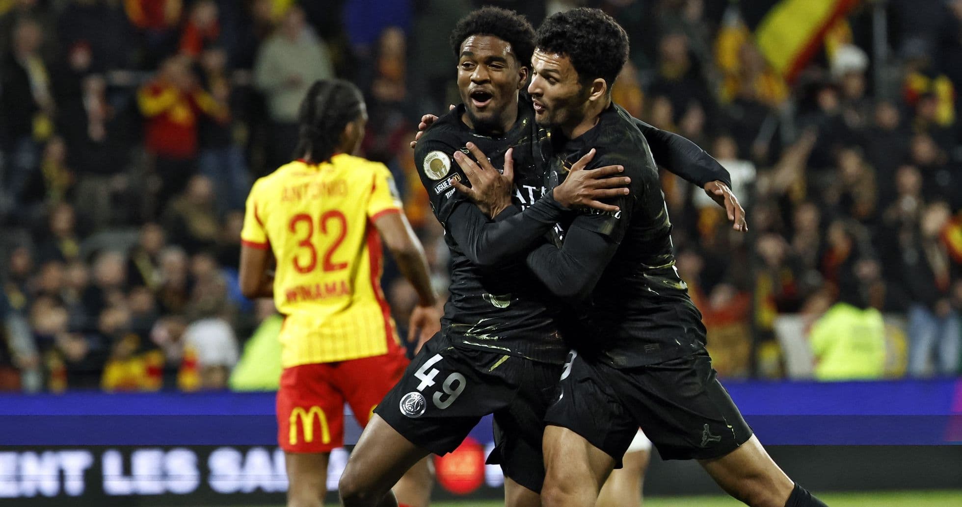Two PSG players celebrating a goal on the field