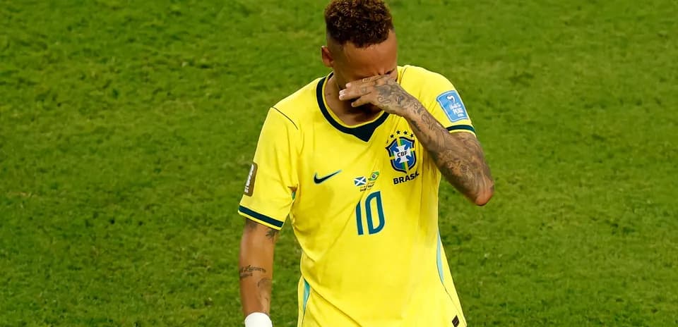 Player in yellow jersey wiping face on field