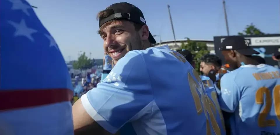 Player smiling during celebratory event in blue jersey
