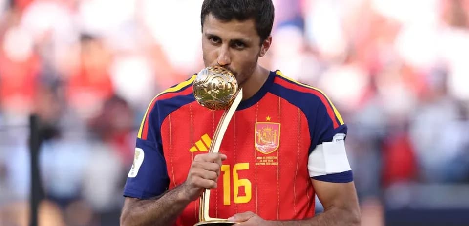 Player in Spain jersey holding a trophy