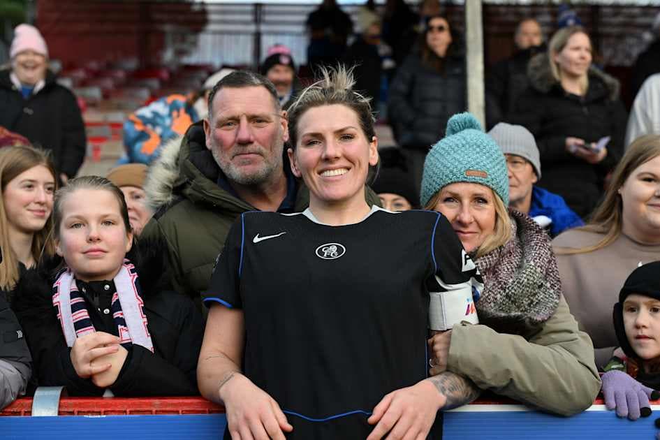 Player posing with fans at stadium railing