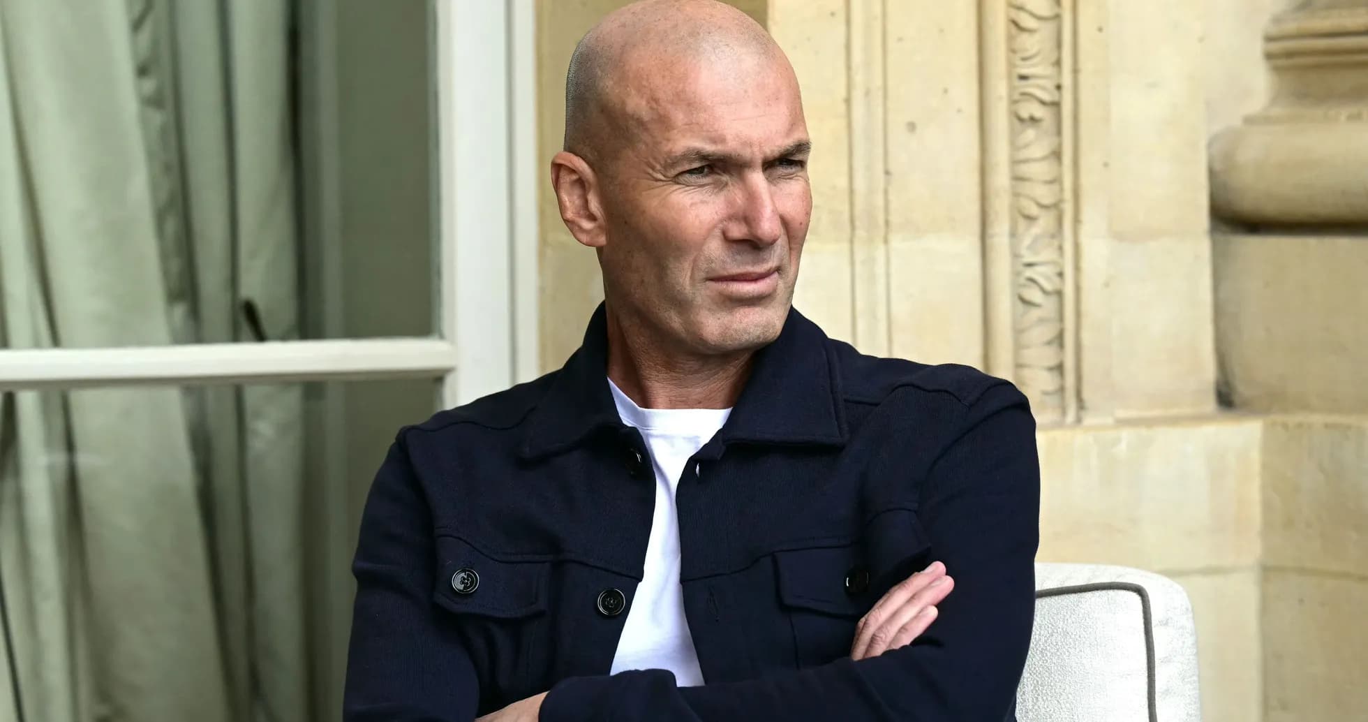 Man sitting with arms crossed, outdoors setting