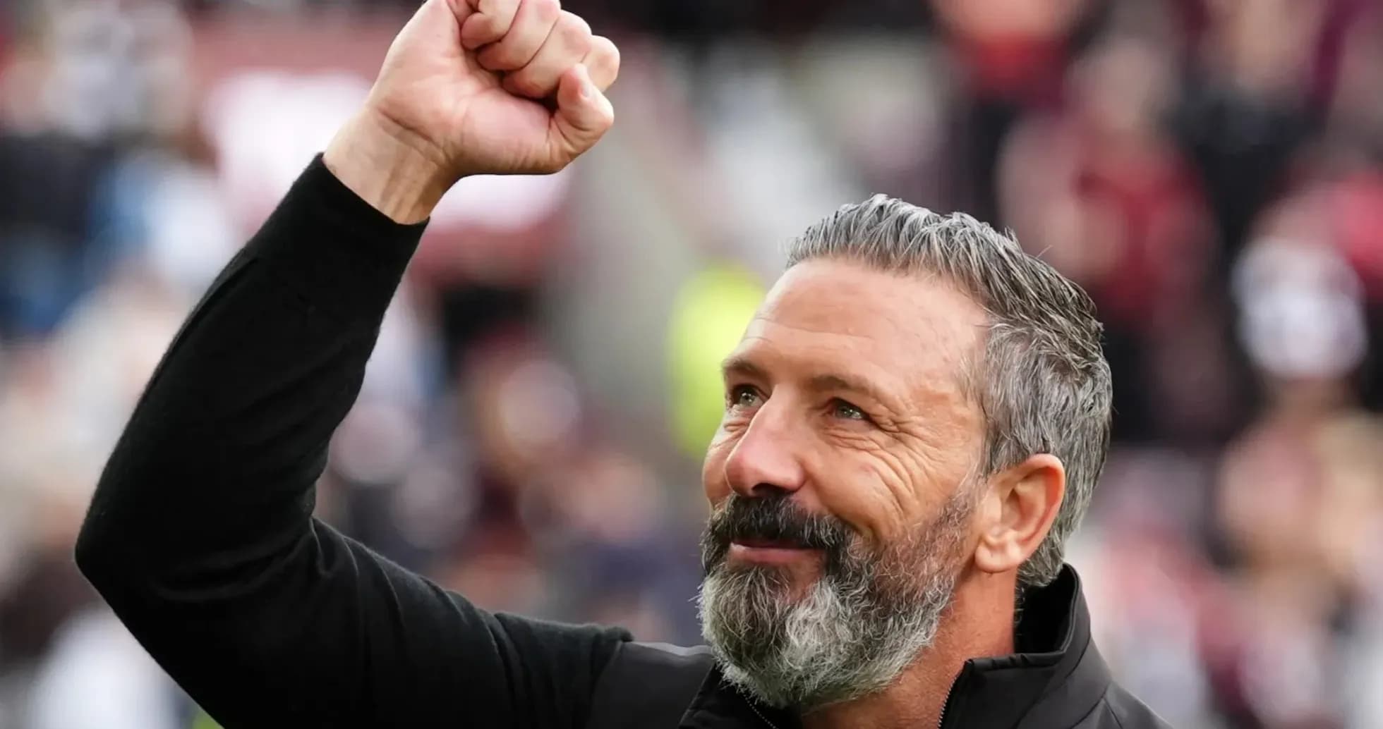 Coach celebrating with a raised fist in crowd
