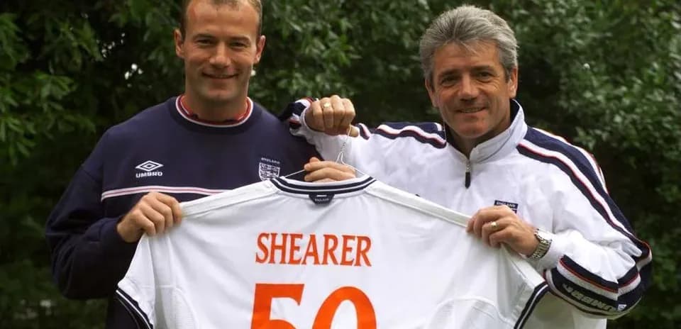 Two men holding a football jersey with 'SHEARER 50'