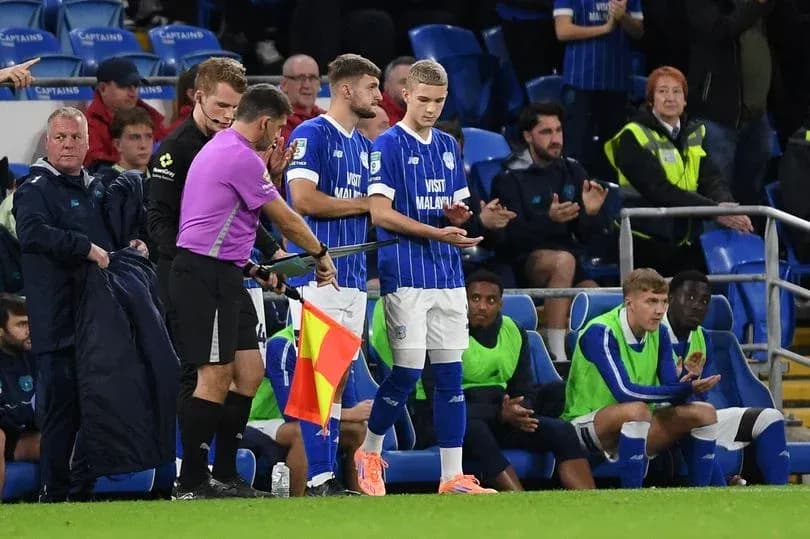 Substitutes preparing to enter the match on sidelines