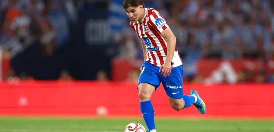 Atletico Madrid player dribbling the ball on field